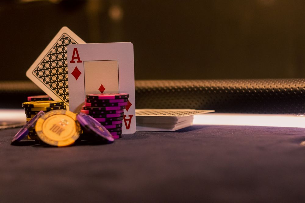 Kartu remi dan chip poker tergeletak di meja permainan