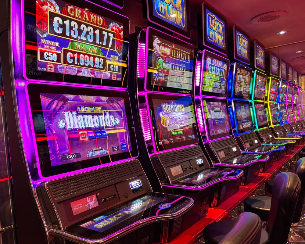 Barisan mesin slot dengan lampu neon di kasino