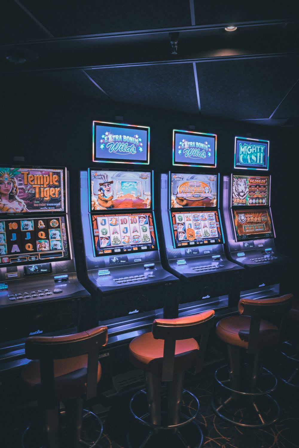 Deretan mesin slot dengan tampilan terang di dalam kasino
